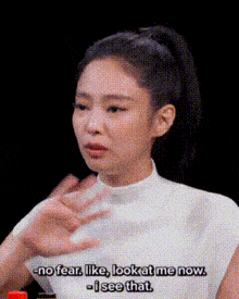 a woman in a white shirt is saying no fear like look at me now and i see that .