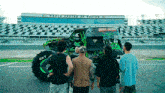a group of men are standing in front of a monster truck that says grave digger