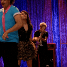 a man playing a guitar with a leopard print skirt