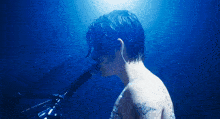 a man is singing into a microphone with a tattoo on his arm