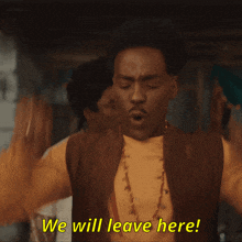 a man says " we will leave here " with his arms in the air