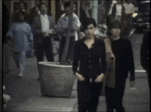 a man and a woman are walking down a street