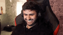 a man wearing headphones is sitting in a gaming chair .