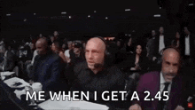 a man in a suit and headphones is standing in front of a crowd while another man points at him .