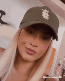 a woman wearing a hat with a # on it is smiling .