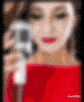a woman in a red dress is taking a picture with a camera and the word vivavideo is on the bottom