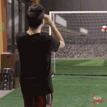 a man wearing headphones stands in front of a soccer goal with the words " black friday " on the bottom