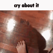 a person 's foot is standing on a wooden floor with the words cry about it below it