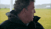 a close up of a man 's face in a field
