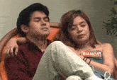a man and a woman are sitting next to each other with the woman holding a card that says bianca on her chest