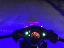 a speedometer on a motorcycle is lit up with blue light
