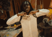 a man in a white shirt has a chain around his neck that says ' bounty ' on it