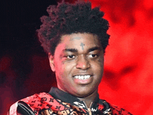a young man with a cross tattoo on his forehead is smiling