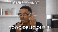 a man wearing glasses is talking on a cell phone .