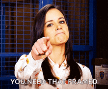 a woman pointing at the camera with the words " you need that framed " written below her