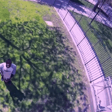 a man in a white shirt is standing in a grassy area