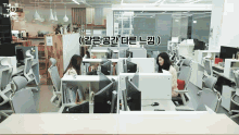 a woman sits at a desk in an office with a dell monitor