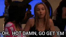 two women are sitting next to each other in a room and talking .