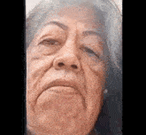 a close up of an elderly woman 's face with a serious look on her face .