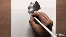 a person is drawing a batman helmet with a pencil on a piece of paper
