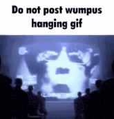 a group of people are watching a hanging gif of a man 's face