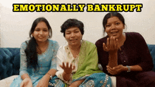 three women are sitting on a blue couch with the words emotionally bankrupt above them