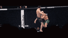 two men are fighting in a boxing ring with a sign that says abu dhabi
