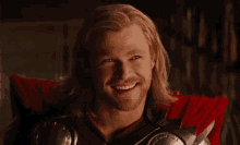 a man with long hair and a beard is smiling .