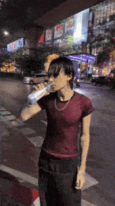 a person is drinking water from a bottle that says evian on it