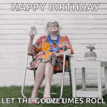 an elderly woman is sitting in a chair holding a glass of beer and a birthday card .