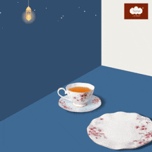 a cup of tea sits on a saucer next to a plate