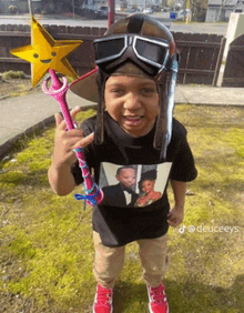 a little boy wearing a helmet and goggles is holding a star and a wand