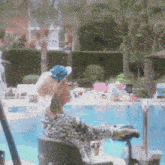 a woman in a wheelchair sits by a swimming pool