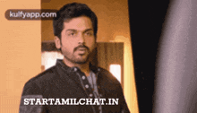 a man with a beard is standing in front of a starttamilchat.in advertisement