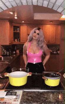 a woman in a pink top is standing in a kitchen