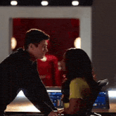 a man and a woman are kissing in front of a computer .