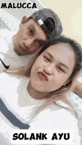 a man and a woman are posing for a picture and the woman is wearing a white nike shirt