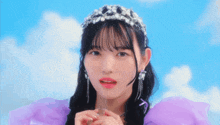 a young girl wearing a purple dress and a tiara .