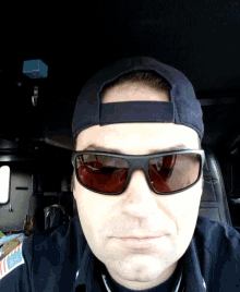 a man wearing sunglasses and a baseball cap is sitting in a car