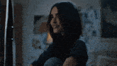 a woman with long dark hair is smiling in a room
