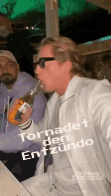 a man is holding a bottle of corona beer in his mouth .
