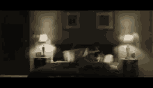 a woman is laying on a bed in a dark room with lamps