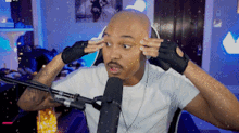 a bald man wearing headphones is sitting in front of a microphone