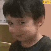 a young boy is making a funny face and smiling .