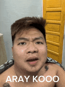 a shirtless man is making a funny face with the words aray kooo on the bottom right