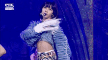 a woman is dancing on a stage with a blue background .