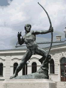 a statue of a man holding a bow and arrow with panadea.com in the corner