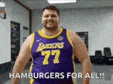 a man wearing a lakers jersey is standing in a gym .