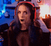 a woman with purple hair wearing headphones and a black shirt