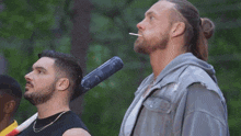 a man smoking a cigarette while holding a bat